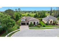 Beautiful exterior view of home with three-car garage, landscaped front yard, and manicured lawn at 21654 Draycott Way, Land O Lakes, FL 34637
