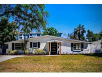 Charming single-story home featuring a stucco exterior, black shutters, and a well-manicured lawn at 331 Barbara Cir, Belleair, FL 33756