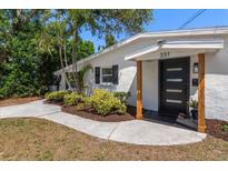 Inviting home entrance with modern black door, new landscaping, and a welcoming walkway at 331 Barbara Cir, Belleair, FL 33756