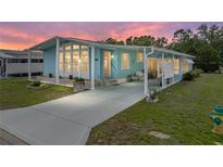 Charming blue home with a covered front porch and well-maintained landscaping in a desirable community at 35026 Colony Hills Dr, Zephyrhills, FL 33541