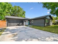 Charming single story home with a well-manicured lawn, dark brick, garage and a concrete driveway at 5907 Tampa Shores Blvd, Tampa, FL 33615