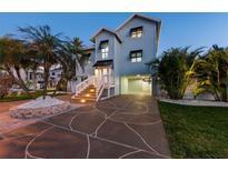 Charming two-story home featuring a paved driveway, tropical landscaping, and a welcoming entrance at 13936 Harbor View Dr, Seminole, FL 33776