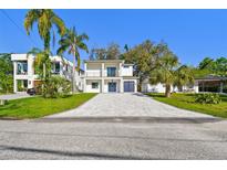 Stunning two-story home with a blue door, attached garage, and a spacious paver driveway at 1045 Jesse Ave, Safety Harbor, FL 34695