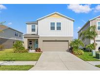 Charming two-story home with a well-manicured lawn and a two-car garage in a residential neighborhood at 12856 French Market Dr, Riverview, FL 33579
