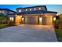 Inviting home with a three-car garage, and well lit at twilight at 18185 Cortes Creek Blvd, Spring Hill, FL 34610