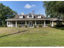 Charming single-story home with a welcoming front porch and well-maintained lawn at 18724 Geraci Rd, Lutz, FL 33548