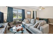 Bright living room with large sofa, glass coffee table, and natural light from the windows at 1900 59Th N Ave # 108, St Petersburg, FL 33714