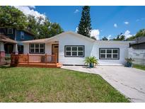 Charming single-story home featuring a new wood deck, fresh white paint, and black trimmed windows at 1906 E Idlewild Ave, Tampa, FL 33610