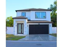 Inviting exterior view of a modern two-story home with a dark garage door and stylish front entrance at 2211 E 28Th Ave, Tampa, FL 33605