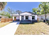 Charming single-story home with a well-manicured lawn and a long concrete driveway at 3205 E North Bay St, Tampa, FL 33610