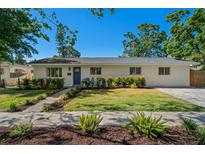 Charming single-story home with a well-manicured lawn and lush landscaping at 347 Patica Ne Rd, St Petersburg, FL 33702