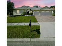 Charming single-story home with manicured lawn, brick driveway, and a two-car garage at 5525 Thorngrove Way, Spring Hill, FL 34609