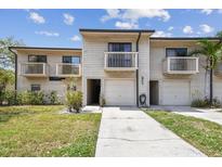 Two-story townhome featuring balconies, a one car garage, and neutral siding at 6343 92Nd N Pl # 2102, Pinellas Park, FL 33782