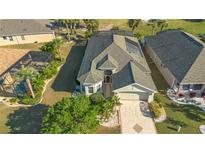 Inviting home with lush landscaping, mature palms, and a spacious driveway in a well-maintained community at 1038 Emerald Dunes Dr, Sun City Center, FL 33573