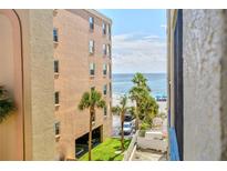 View of complex with manicured grounds and ocean view in the background, offering a tropical paradise at 12924 Gulf Blvd # 310, Madeira Beach, FL 33708
