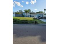 Charming single-story home featuring a well-maintained lawn, palm tree, and inviting front porch at 1329 Tuscola St, Clearwater, FL 33756