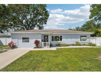 Charming single-story home with well-manicured lawn, white picket fence, and lovely landscaping at 2362 Mary Ln, Clearwater, FL 33763