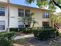A charming condo features a two-story facade with manicured landscaping, enhancing its curb appeal at 3358 Mermoor Dr # 2106, Palm Harbor, FL 34685