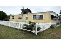 Charming single-story home featuring a white picket fence and well-maintained lawn at 4116 Cardoon Dr, New Port Richey, FL 34653
