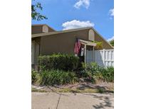 Charming home featuring a welcoming front entrance with lovely landscaping and an American flag at 7112 Eldorado Dr, Tampa, FL 33615