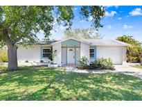 Charming single-story home featuring a well-manicured lawn, light blue accents, and an attached garage at 10790 92Nd St, Seminole, FL 33777
