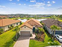 Beautiful single-story home with well-manicured lawn, red tile roof, and a scenic lake in a Florida community at 11248 Juglans Dr, Odessa, FL 33556
