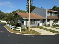 Charming townhome with a well-maintained yard and a white picket fence on a corner lot at 1200 Abbey Crescent Ln, Clearwater, FL 33759