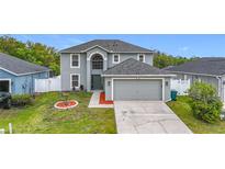 Charming two-story home featuring a two-car garage, well-maintained lawn, and inviting curb appeal at 25029 Hyde Park Blvd, Land O Lakes, FL 34639