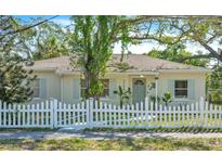 Charming single-story home with a white picket fence and lush landscaping, creating a welcoming curb appeal at 2708 5Th S St, St Petersburg, FL 33705