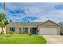 Charming single-story home with a well-manicured lawn, attached garage, and vibrant turquoise shutters and front door at 3410 5Th W Dr, Palmetto, FL 34221