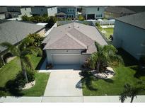 Aerial view of a single-Gathering home showcasing its well-maintained lawn and mature landscaping at 9736 Sage Creek Dr, Ruskin, FL 33573