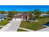 Charming single-story home featuring a three-car garage and well-manicured lawn at 14296 Pullman Dr, Spring Hill, FL 34609