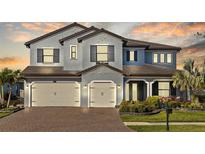 Stunning two-story home with a three-car garage, beautiful landscaping, and a brick driveway at 28355 Picana, Wesley Chapel, FL 33543