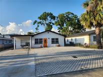 Charming single-story home boasts a spacious parking area, fresh exterior paint, and a welcoming orange front door at 4119 W Nassau St, Tampa, FL 33607