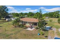 Inviting single-story home with mature trees and a cozy front patio for relaxing and entertaining at 4615 Keene Rd, Plant City, FL 33565
