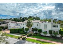 Elegant two-story home featuring manicured landscaping and a clay tile roof at 1102 Palm View Ave, Belleair, FL 33756