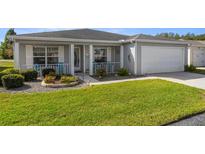 Charming single-story home featuring a manicured lawn, flower beds, and a two-car garage at 29408 Princeville Dr, San Antonio, FL 33576