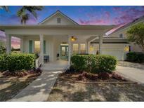 Charming home featuring a welcoming front porch, lush landscaping, and a two-car garage at 308 Manns Harbor Dr, Apollo Beach, FL 33572