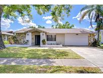 Charming single-story home with stone accents, a two-car garage, and well-maintained lawn at 4110 Summerdale Dr, Tampa, FL 33624