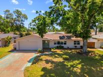 Charming single-story home featuring a lush green lawn and mature trees providing shade and curb appeal at 6470 28Th N Ter, St Petersburg, FL 33710