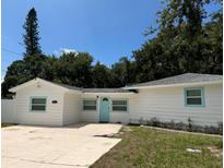 Charming single-story home with a well-maintained lawn, a light blue door and matching window trim at 7202 8Th N Ave, St Petersburg, FL 33710