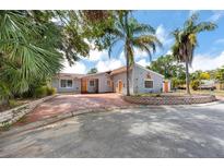 Charming single-story home with well-maintained landscaping, orange doors, and a spacious red-paved driveway at 157 7Th Sw Ave, Largo, FL 33770