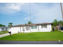 Charming single-story home with a well-manicured lawn and bright white exterior at 1741 Fairfield St, Holiday, FL 34691