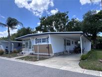 Charming manufactured home featuring a carport, covered patio, and neatly maintained landscaping at 2331 Belleair Rd # 904, Clearwater, FL 33764
