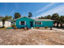 A single-story home with light blue exterior, complemented by palm trees in the yard at 340 83Rd Ave, St Pete Beach, FL 33706