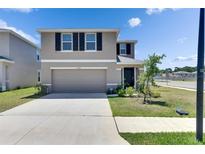Two story home with neutral paint, black shutters, and well manicured lawn at 35260 Spruce Knob Ct, Dade City, FL 33525