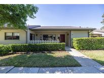 Charming front exterior featuring a well-manicured lawn, hedges, and inviting entrance in a cozy community at 40 Gretchen Ct, Oldsmar, FL 34677