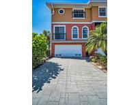Charming multi-story home featuring a two-car garage, balcony, and well-maintained paver driveway at 47 W Morgan St, Tarpon Springs, FL 34689