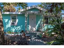 Charming aqua home featuring a quaint front porch with decorative metal supports at 515 77Th Ave, St Pete Beach, FL 33706