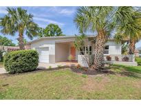 Charming home featuring mature landscaping with palm trees and a cozy front porch at 5833 Dartmouth N Ave, St Petersburg, FL 33710
